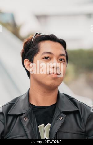 Le visage d'un homme asiatique très idiot avec des lunettes de soleil sur la tête tout en se relaxant dans un café pendant la journée Banque D'Images