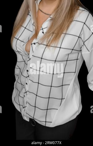 Femme avec les cheveux blonds à la mode et style blouse blanche avec motif noir abstrait de lignes carrées rayures sur fond sombre. Banque D'Images