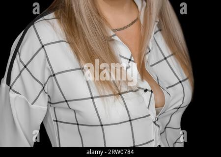 Femme cheveux blonds dans le style de la mode blouse blanche avec motif noir abstrait lignes carrées rayures sur fond sombre. Banque D'Images