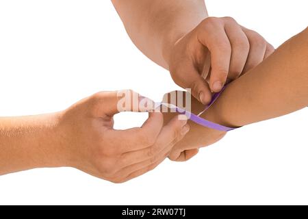 Les mains des personnes attachent un ruban de passage à un festival ou un événement, gros plan sur un fond blanc, isolé. Banque D'Images