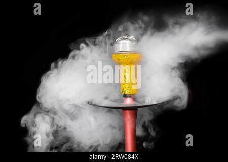 Hookah jaune abstrait bol en céramique fumant objet blanc fumée sur fond noir. Banque D'Images