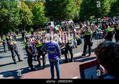 On voit des policiers entourer les militants qui bloquent la route. Plusieurs organisations climatiques ont organisé une grève scolaire contre les combustibles fossiles. Cette grève est organisée dans le cadre de plus de 400 actions organisées à travers le monde pour lutter pour la fin des énergies fossiles. La manifestation comptait sur un cortège d'enseignants des universités du pays qui soutenaient la manifestation. Cette manifestation a eu lieu près de l'autoroute A12, où les manifestants de la rébellion de l'extinction bloquent la route quotidiennement. Les manifestations sont prévues juste avant le Sommet de l'ambition climatique des Nations Unies, Banque D'Images