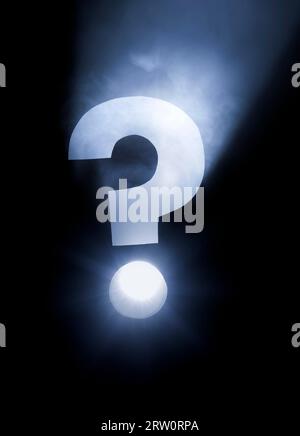Point d'interrogation. Trou découpé dans le carton, machine à fumée et projecteur. L'image peut sembler bruyante, mais c'est la texture de la fumée Banque D'Images