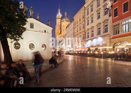 Ville de Cracovie de nuit en Pologne. Place principale dans la vieille ville, église de St. Wojciech sur la gauche, maisons d'habitation et basilique Sainte-Marie au loin Banque D'Images