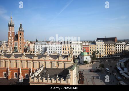 Ville de Cracovie en Pologne, place du marché principal dans la vieille ville avec salle aux draps (Sukiennice), maisons historiques et St. Mary Church sur la gauche Banque D'Images