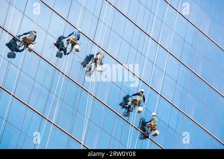 Nettoyer les vitres des travailleurs en équipe sur un gratte-ciel dans le centre-ville de Séoul, Corée du Sud Banque D'Images