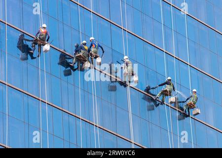 Nettoyer les vitres des travailleurs en équipe sur un gratte-ciel dans le centre-ville de Séoul, Corée du Sud Banque D'Images