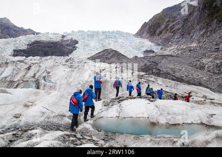 Franz Josef, Nouvelle-Zélande, 22 mars 2015 : un groupe de touristes fait une randonnée vers un hélicoptère sur le glacier Franz Josef Banque D'Images