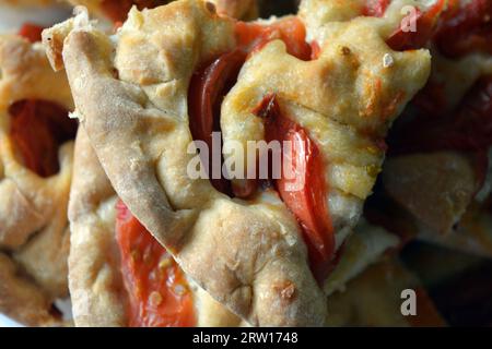 Gâteaux faits maison, délicieux et sain grand gâteau avec des morceaux, tranches de tomates disposées sur une grande plaque de verre blanc. Banque D'Images