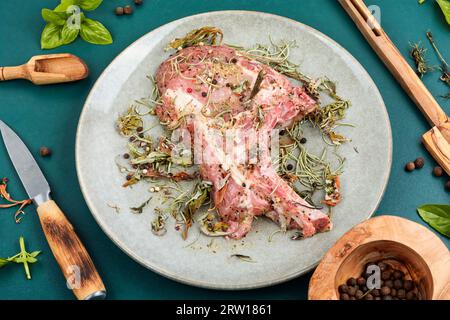 Steak de porc cru Tomahawk mariné avec des herbes épicées pour griller. Viande fraîche. Banque D'Images