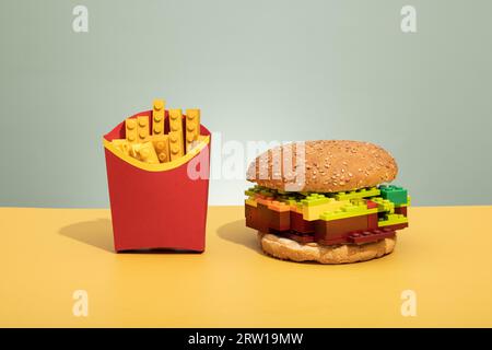 hamburger et frites fabriqués à partir de briques lego sur fond de couleur, photo concept en plastique, malbouffe. Photo de haute qualité Banque D'Images