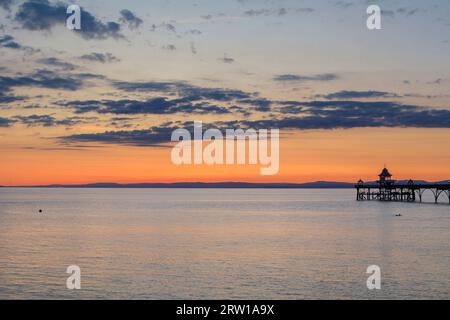 Clevedon Pier lors d'une soirée lumineuse et colorée alors que le soleil est sur le point de se coucher sur la côte galloise Banque D'Images