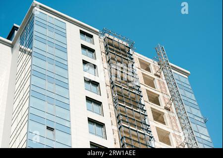 Vue à faible angle d'un bâtiment moderne en construction avec le ciel bleu comme arrière-plan. Banque D'Images