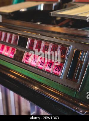 Juke-box de musique américaine vintage avec boutons illuminés, processus de choix de la composition de la chanson, juke-box rétro à l'ancienne avec disques vinyles musicaux b Banque D'Images