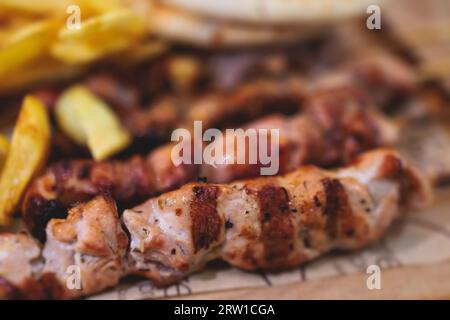 Vue de Souvlaki sur une assiette - plat de cuisine grecque traditionnelle avec un poulet barbecue grillé avec frites et sauce tzatziki servi dans un café taverne Banque D'Images