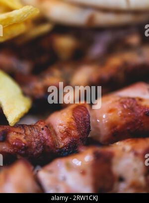 Vue de Souvlaki sur une assiette - plat de cuisine grecque traditionnelle avec un poulet barbecue grillé avec frites et sauce tzatziki servi dans un café taverne Banque D'Images