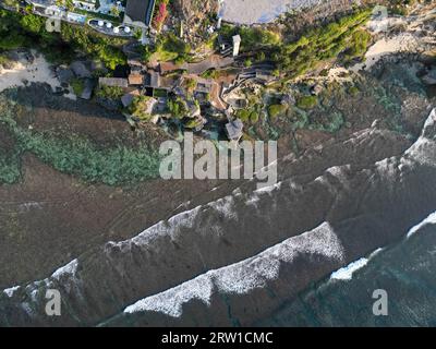 Vue aérienne de la falaise d'uluwatu, eau cristalline et ciel bleu Banque D'Images