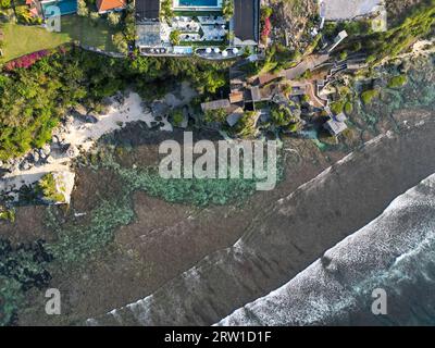 Vue aérienne de la falaise d'uluwatu, eau cristalline et ciel bleu Banque D'Images