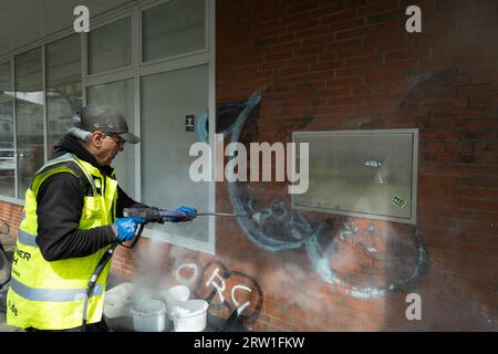 20.04.2023, Allemagne, Brême, Brême - une entreprise spéciale enlève les graffitis désagréables d'un mur de maison avec un nettoyeur haute pression (HDR), de l'eau avec un chemi Banque D'Images