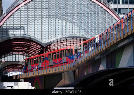 Le train DLR sur des voies surélevées traverse Middle Dock vers la gare de Canary Wharf au cœur du quartier financier de Canary Wharf le 15 août 2023 à Londres, Royaume-Uni. Canary Wharf est une zone située près de l'île des chiens dans le quartier londonien de Tower Hamlets et est définie par la Greater London Authority comme faisant partie du quartier central des affaires de Londres. Avec la ville de Londres, il constitue l'un des principaux centres financiers du Royaume-Uni et du monde, contenant de nombreux immeubles de grande hauteur, dont le troisième plus haut du Royaume-Uni, One Canada Square. Le train léger Docklands Banque D'Images