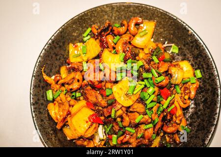 Poulet noix de cajou sans gluten plein de goût umami, mélangé avec du piment séché, des oignons et des noix de cajou Banque D'Images