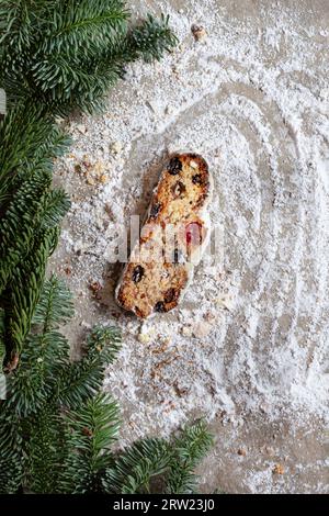 Dresde Christmas Stollen avec raisins secs, abricots secs, cerises, noix et fruits confits dans un glaçage au sucre sur un fond festif. Délicieux Noël Banque D'Images