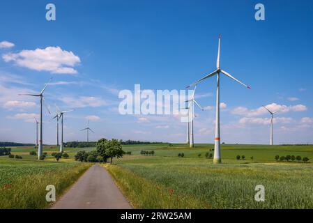 04.07.2023, Allemagne, Rhénanie du Nord-Westphalie, Lichtenau - Parc éolien dans le paysage agricole avec champs, collines, chemin de champ et arbres. 00X230704D019CA Banque D'Images