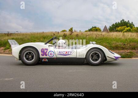 Années 1965 60 années soixante blanc violet McLaren 5987 cc M1A à l'Ocean Speed Revival Southport Sprint sur Marine Drive, classique et vitesse sur une route publique fermée Coastal Road parcours de sprint historique, Merseyside, Royaume-Uni Banque D'Images