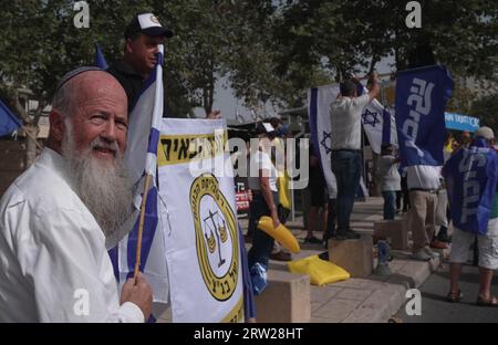 Des manifestants pro-gouvernementaux de droite chantent des slogans lors d'une manifestation en faveur du plan de réforme judiciaire du gouvernement israélien devant la Cour suprême alors que quinze juges de la Cour suprême se réunissent pour entendre des pétitions contre le « projet de loi sur le caractère raisonnable » du gouvernement le 12 septembre 2023 à Jérusalem, en Israël. La norme de la décision raisonnable est une doctrine de common law qui permet aux tribunaux de procéder à des contrôles judiciaires de décisions administratives gouvernementales qui vont bien au-delà de ce que ferait une autorité raisonnable et responsable. Banque D'Images