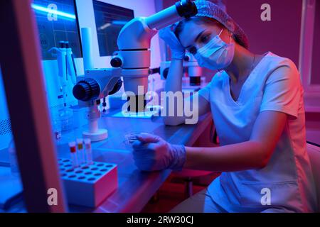 Jeune femme fatiguée au travail dans un laboratoire moderne Banque D'Images