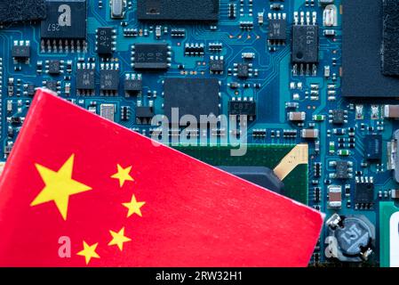 Un concept de technologie chinoise avec drapeau chinois sur le dessus d'une carte de circuit imprimé semi-conducteur. Banque D'Images