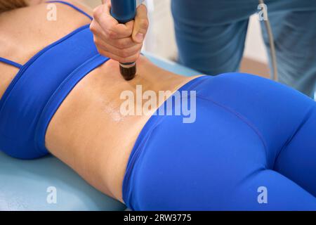 Orthopédiste masculin utilisant la thérapie extracorporelle par ondes de choc Banque D'Images