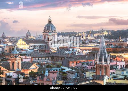 Vue sur le paysage urbain de Terrazza Viale del Belvedere à Villa Borghese sur les toits de la ville et les lumières de Rome, Italie au coucher du soleil. Banque D'Images