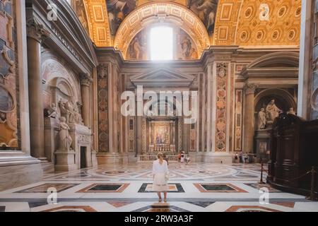Cité du Vatican - 28 août 2023 : une jeune touriste blonde explore l'intérieur extravagant de la basilique Saint-Pierre, maison de la catholique romaine Banque D'Images