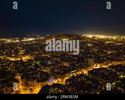 Blocs de construction traditionnels dans le quartier urbain la nuit. Vue panoramique aérienne de la métropole illuminée. Barcelone, Espagne Banque D'Images