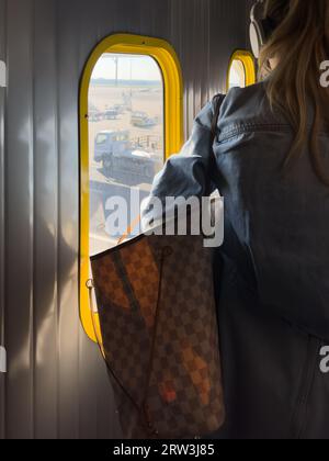 Une belle femme blonde embarquant dans un avion pour la Sardaigne, en Italie Banque D'Images