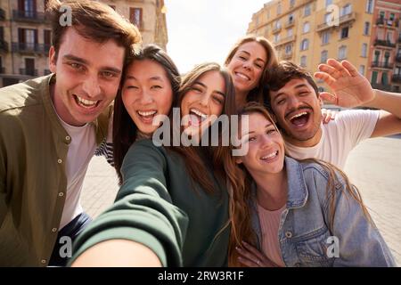 Selfie mobile de groupe de jeunes amis multi-ethniques s'amusant ensemble à l'extérieur. Des gens excités. Banque D'Images