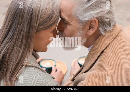 Portrait de couple senior affectueux embrassant dehors, gros plan Banque D'Images