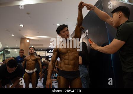 Bangkok, Thaïlande. 16 septembre 2023. L'assistant de l'athlète peint le bronzage sur le corps d'un athlète de culturisme, avant de monter sur scène pour concourir aux Championnats de muscle et de physique de Thaïlande 2023 le 16 septembre 2023. Au Central Rama 2 Department Store, Bangkok, Thaïlande. (Image de crédit : © Teera Noisakran/Pacific Press via ZUMA Press Wire) USAGE ÉDITORIAL SEULEMENT! Non destiné à UN USAGE commercial ! Banque D'Images