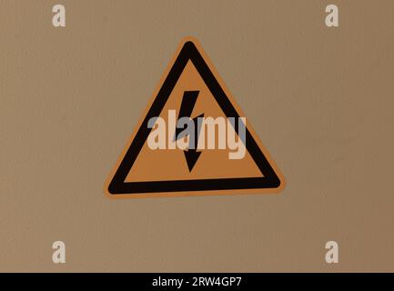 Signe de danger électrique placé sur une clôture métallique. Banque D'Images