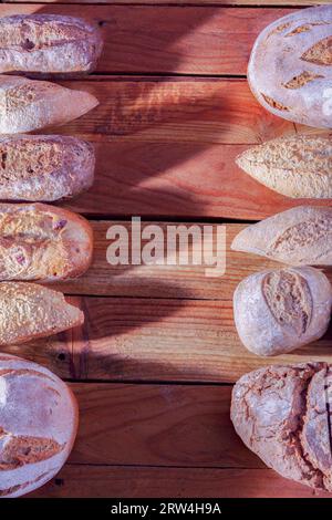 Différents types de pains et pains de pain artisanal rustique dans une rangée sur une table en bois avec un espace de copie au centre Banque D'Images