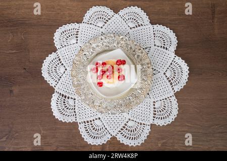 Biscuits à la noix de coco avec groseilles servis dans un petit bol sur une couverture crochetée. Vue plongeante Banque D'Images