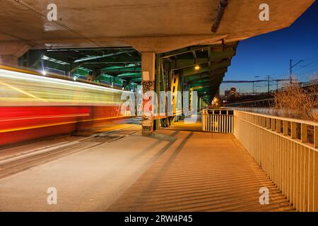 Tramway léger et arrêt de nuit dans la partie inférieure du pont de Gdanski en treillis métallique à Varsovie, Pologne Banque D'Images