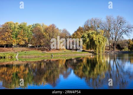 Lac avec réflexion sur l'eau en automne, parc Moczydlo dans la ville de Varsovie, Pologne Banque D'Images