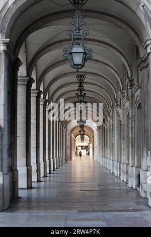 Arcade avec plafond voûté et lampes ornées en fer forgé dans le bâtiment de Praca do Comercio à Lisbonne, Portugal Banque D'Images