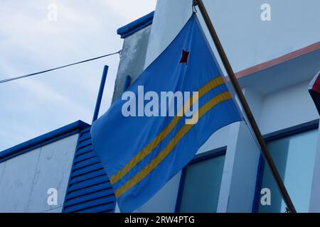 Drapeau Aruba et ciel bleu avec des nuages. Banque D'Images