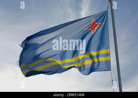 Drapeau Aruba et ciel bleu avec des nuages. Banque D'Images