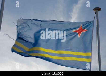 Drapeau Aruba et ciel bleu avec des nuages. Banque D'Images