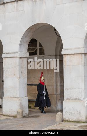 Garde à la Royal Horseguard Parade. Garde vêtue d'un uniforme complet et épée marchant sous les arches à la Royal Horseguard Parade à Londres. Banque D'Images