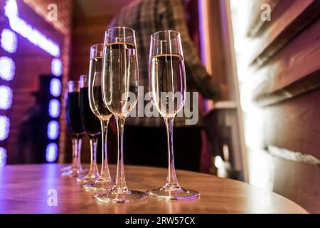 Champagne frais ou vin mousseux blanc, alcool dans un verre, vin rouge sur la table un fond flou de l'intérieur. Banque D'Images